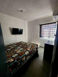 a bedroom with a bed and a flat screen tv at Casa Alelies in Puerto Peñasco