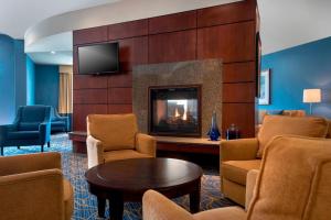 a living room with a fireplace in a hotel room at Courtyard by Marriott Saratoga Springs in Saratoga Springs