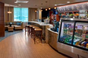 a restaurant with a bar with stools and a drink cooler at Courtyard by Marriott Saratoga Springs in Saratoga Springs