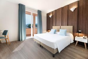 マリーナ・ディ・カンポにあるホテル リヴァ デル ソーレの大きな白いベッドと窓のある寝室