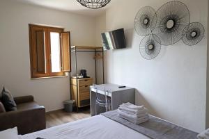 ein Schlafzimmer mit einem Bett, einem Sofa und einem Ventilator in der Unterkunft B&B Casa Madeo in San Demetrio Corone