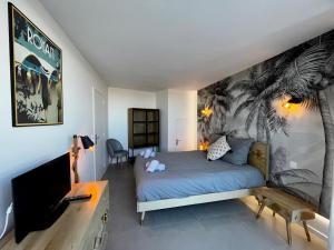 - une chambre avec un lit orné d'une fresque murale de palmiers dans l'établissement L'Escale SUNRISE panorama sur l'estuaire, à Royan