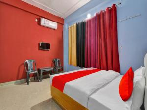 a bedroom with a bed with red and blue walls at Flagship Hotel Aradhya Galaxy in Bhauli