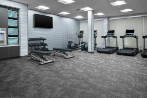 a gym with tread machines and a flat screen tv at Fairfield by Marriott Inn & Suites Dallas DFW Airport North, Irving in Irving