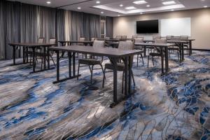 Fairfield by Marriott Inn & Suites Dallas DFW Airport North, Irving في ايرفينغ: قاعة اجتماعات مع طاولات وكراسي وشاشة