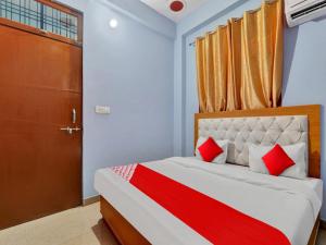 a bedroom with a bed with red pillows and a door at Flagship Hotel Aradhya Galaxy in Bhauli