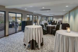 a banquet room with tables and chairs and windows at Courtyard Hartford Cromwell in Cromwell