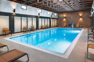 a large swimming pool in a building with tables and chairs at Courtyard Hartford Cromwell in Cromwell
