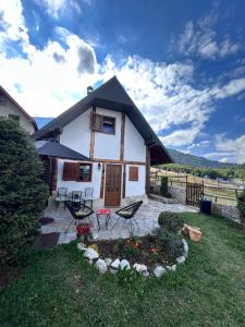 a house with a patio and chairs in the yard at NV Mountain House in Žabljak