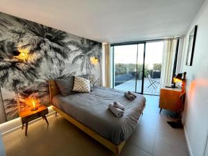 sypialnia z łóżkiem z tropikalną tapetą w obiekcie L'Escale SUNRISE panorama sur l'estuaire w mieście Royan
