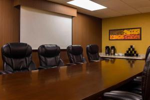 une salle de conférence avec une grande table et des fauteuils en cuir dans l'établissement Courtyard by Marriott Baton Rouge Acadian Centre/LSU Area, à Bâton-Rouge