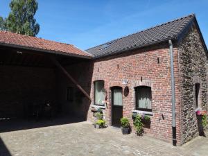 a brick building with two windows and a door at Holiday home Gîte rural Côté Fagnes in Jalhay