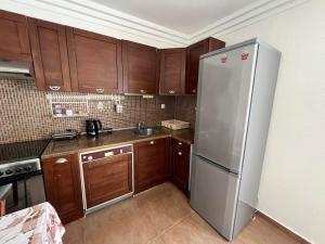 a kitchen with wooden cabinets and a stainless steel refrigerator at HOUSE ALLA in Pefkohori