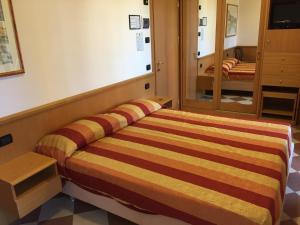 a bedroom with a bed with a striped blanket at Hotel Fiorella in Senigallia