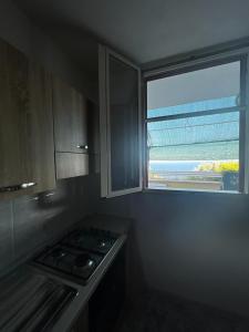 een keuken met een fornuis en een raam erin bij Casa vacanze di Anna in Corsano