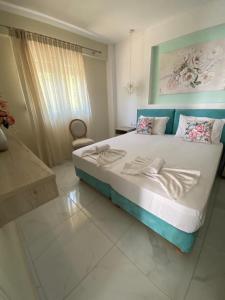 a bedroom with a large bed with a blue headboard at INROY SEA VIEW APARTMENTS in Skala Potamias