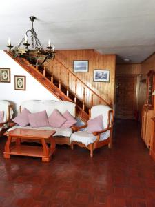 a living room with a couch and a staircase at Chalet entero con patio in Oteruelo del Valle