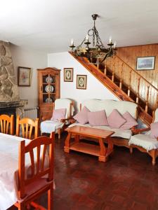 sala de estar con sofá y escalera en Chalet entero con patio, en Oteruelo del Valle