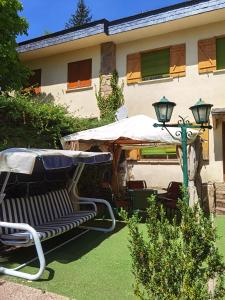 a patio with a table and an umbrella and chairs at Chalet entero con patio in Oteruelo del Valle