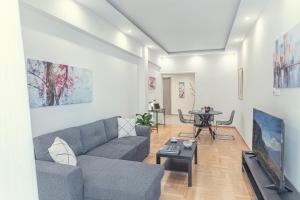 uma sala de estar com um sofá e uma mesa em Amazing apartment near metro Station! em Atenas