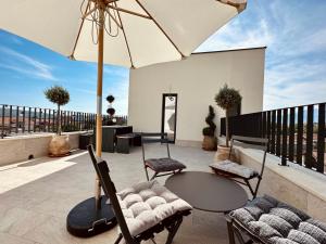 eine Terrasse mit einem Tisch, Stühlen und einem Sonnenschirm in der Unterkunft Adriatic Dream in Tivat
