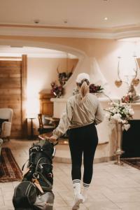 a woman pulling a bag of luggage in a room at Hotel Rosenhof Murau in Murau