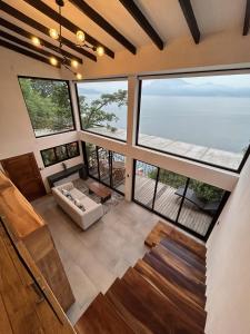 Atitlan Sunset Lodge في سانتا كروز لاغونا: غرفة كبيرة مع نوافذ كبيرة والمحيط