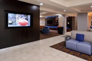- un salon avec une télévision et un canapé dans l'établissement Courtyard by Marriott Milwaukee North/Brown Deer, à Brown Deer