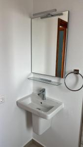 a bathroom with a white sink and a mirror at El Caleton Sea View Apartment in Cotillo +12 photos