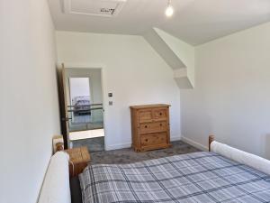 1 dormitorio con 2 camas, tocador y espejo en Brand New Barn Retreat en Bedford