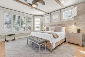 a bedroom with a bed with a bench and windows at West Red Pine Oasis in Park City