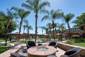 a patio with a table and chairs and palm trees at Courtyard Los Angeles Burbank Airport in Burbank