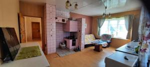 a small kitchen with a pink tiled wall at Nakvynė keliaujantiems in Toliejai