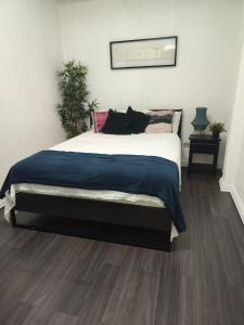 een slaapkamer met een groot bed en een blauwe deken bij Aparthotel Genova in Santo Domingo