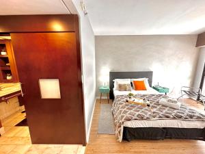 Schlafzimmer mit einem Bett und einer Tür, die in ein Zimmer führt in der Unterkunft Lindo Studio com Jacuzzi e sacada a 50m Av Paulista in São Paulo