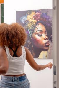 a woman looking at a painting of a black woman at Januarius Domus in Naples