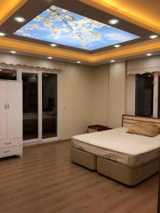 - une chambre avec un grand lit et un plafond bleu dans l'établissement Cottage Samanli, à Yalova