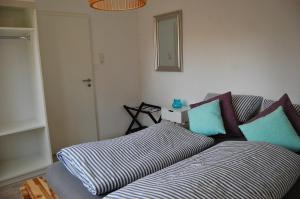ein Wohnzimmer mit einem Sofa mit blauen und weißen Kissen in der Unterkunft Hus Oldewurth in Oldenswort