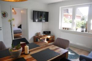 ein Wohnzimmer mit einem Holztisch und einem Esszimmer in der Unterkunft Hus Oldewurth in Oldenswort