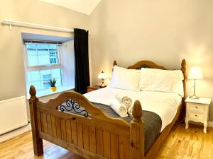sypialnia z drewnianym łóżkiem i oknem w obiekcie Picturesque Riverview Cottage Pettigo w mieście Pettigoe