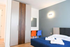 a bedroom with a bed with blue sheets and orange chairs at Bellagio Dreams,Luxury Apartment in Bellagio