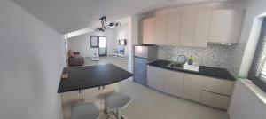 een keuken met witte kasten en een zwart aanrecht bij Apartments Boljat in Trogir