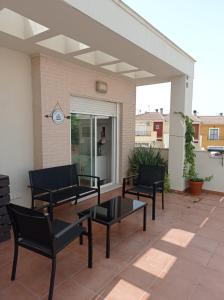 un patio con sillas negras y una mesa en APARTAMENTOS TURISTICOS LAS CINCO JOYAS, en Linares