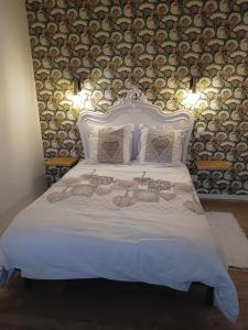 ein Schlafzimmer mit einem Bett mit einer weißen Tagesdecke in der Unterkunft La Petite Maison Dans La Prairie in Écommoy