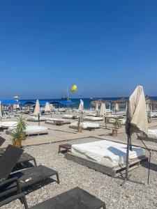 a group of lounge chairs and umbrellas on a beach at Cebel Tiny House&Bungalovs in Kemer