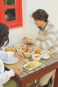 two people sitting at a table eating food at Aldeia da Pedralva - Slow Village in Vila do Bispo