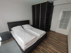 Tonkielek - Domek z Jacuzzi Nad Rzeką Bug في Tonkiele: غرفة نوم مع سرير كبير مع اللوح الأمامي الأسود