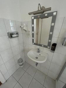 a white bathroom with a sink and a mirror at West End Apartments in Frankfurt/Main