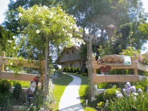 un jardin avec une porte en bois et une maison dans l'établissement Nussbaumerhof, 