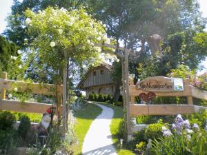 un jardin avec une porte en bois et une maison dans l'établissement Nussbaumerhof, à Sankt Michael am Bruckbach
